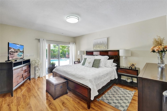 bedroom featuring light wood-type flooring and access to outside