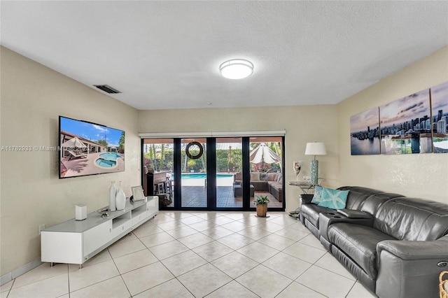 living room featuring french doors, visible vents, light tile patterned floors, and a textured ceiling