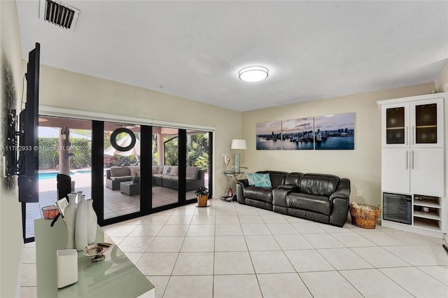 living area with french doors, visible vents, light tile patterned floors, and a healthy amount of sunlight