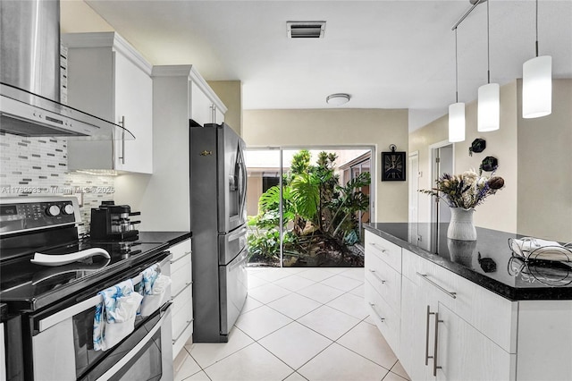 kitchen featuring light tile patterned floors, visible vents, wall chimney exhaust hood, decorative backsplash, and appliances with stainless steel finishes