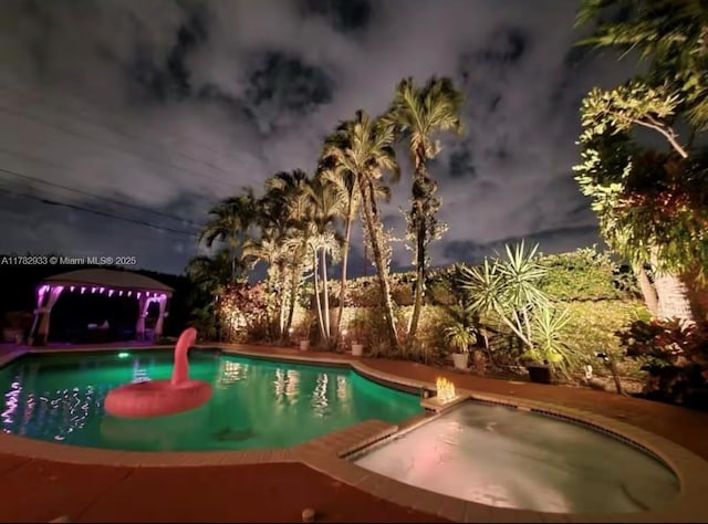 view of pool with a pool with connected hot tub