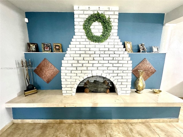 living area featuring tile patterned floors, baseboards, and a fireplace