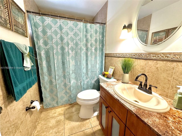 full bathroom featuring curtained shower, toilet, vanity, wainscoting, and tile patterned floors