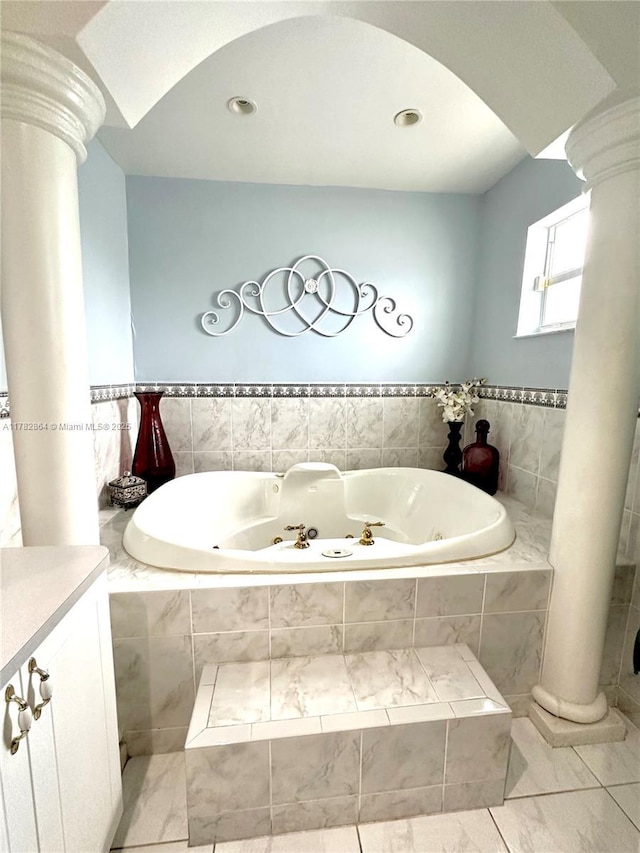 full bath with recessed lighting, ornate columns, and a tub with jets