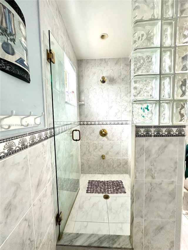 bathroom featuring a shower stall and tile walls
