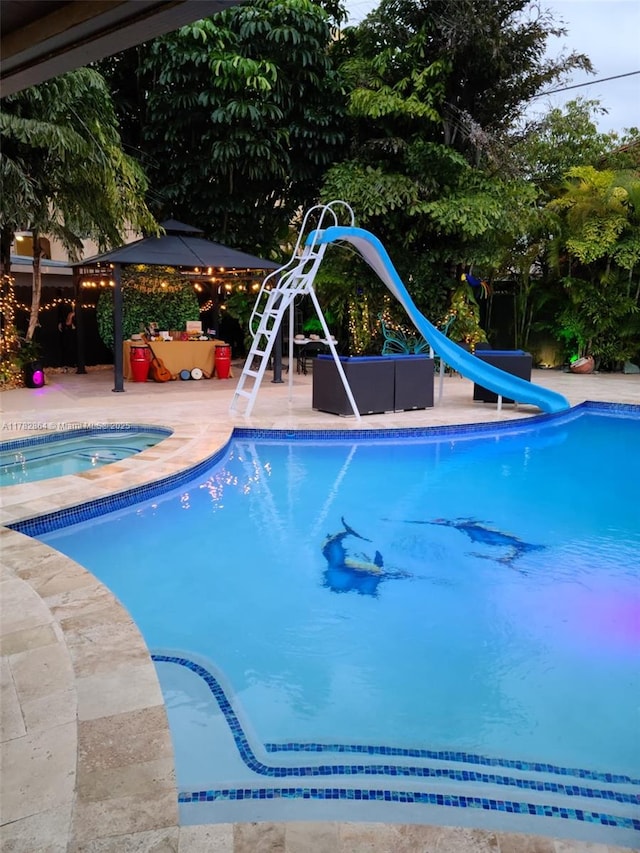 outdoor pool featuring a patio and a water slide