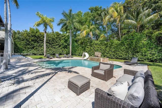 31 Island Dr, Key Biscayne, FL 33149 - swimming pool with a water slide, a patio, view of scattered trees, and an outdoor hangout area