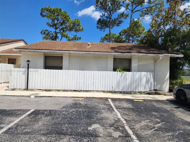 6120 Newstead Ct, Green Acres, FL 33463 - view of side of property featuring uncovered parking, a fenced front yard, and stucco siding