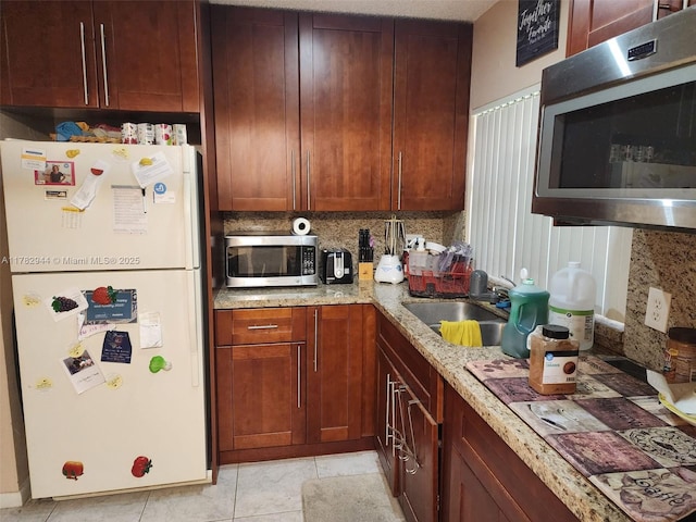 6120 Newstead Ct, Green Acres, FL 33463 - kitchen featuring stainless steel microwave, a sink, freestanding refrigerator, and light stone counters