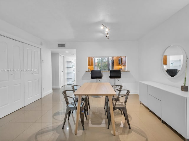 dining space with light tile patterned floors, visible vents, and baseboards