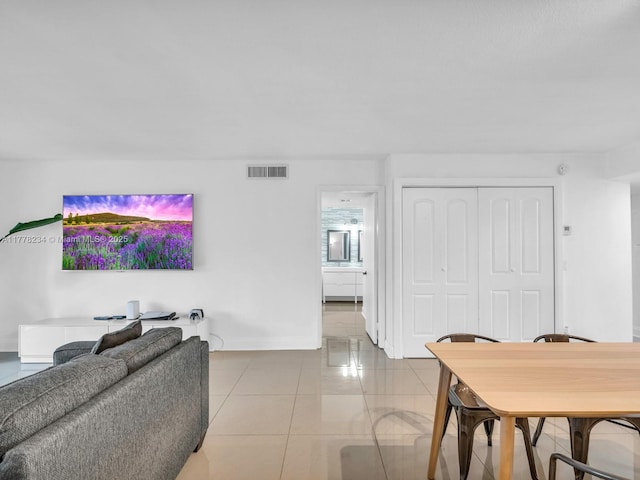 living room featuring light tile patterned floors, baseboards, and visible vents