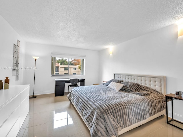 tiled bedroom featuring a textured ceiling and baseboards