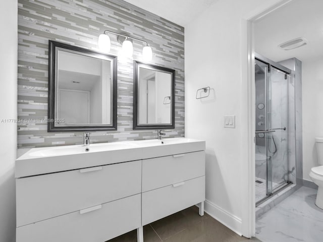 full bathroom featuring a sink, toilet, a stall shower, and baseboards