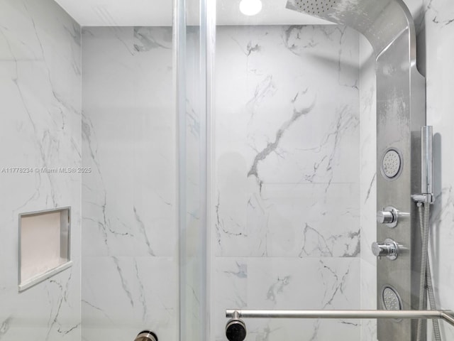 bathroom featuring a marble finish shower