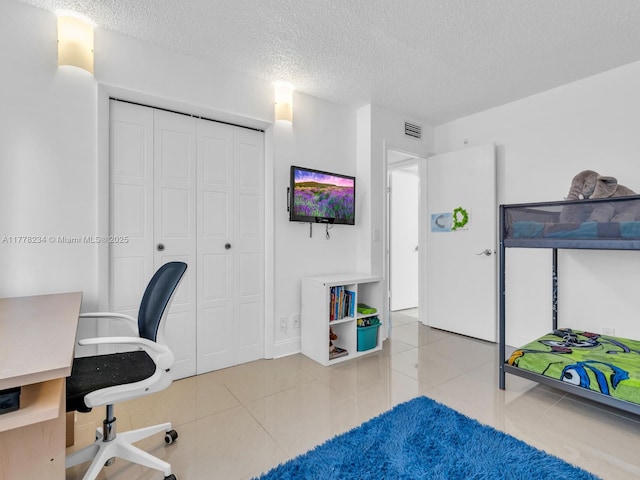 unfurnished office featuring a textured ceiling, tile patterned flooring, and visible vents