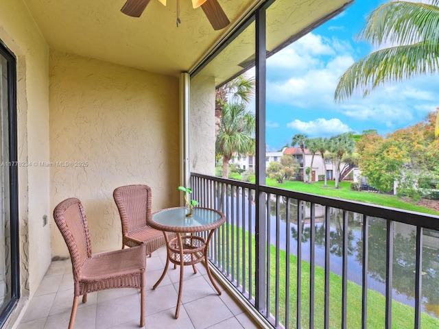 balcony with a ceiling fan and a water view