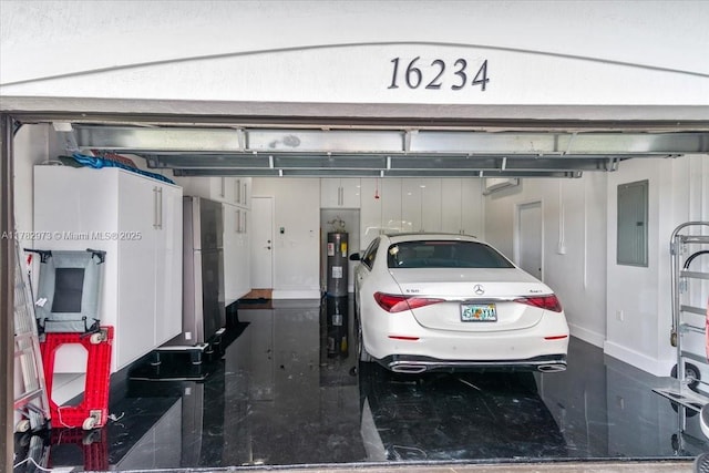 garage with electric panel, baseboards, and freestanding refrigerator