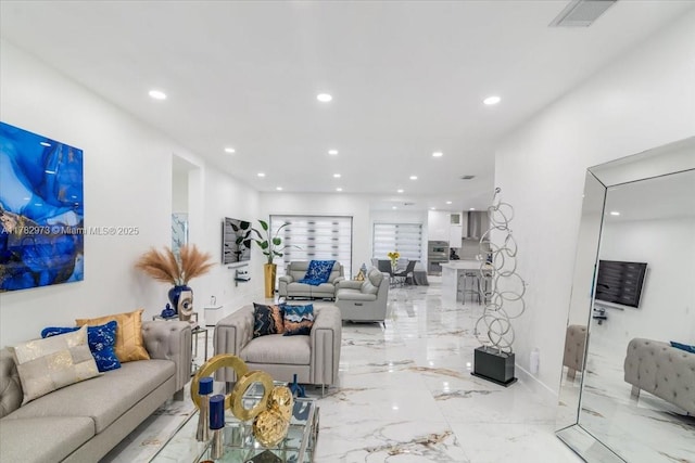 living area with recessed lighting, visible vents, and marble finish floor