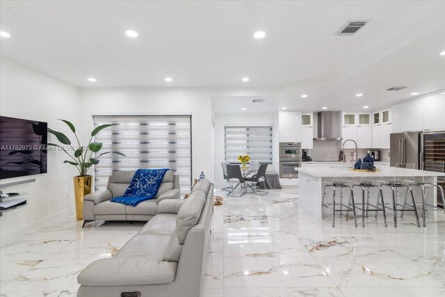 living area with marble finish floor, visible vents, and recessed lighting