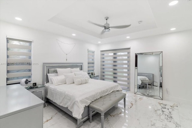 bedroom with a tray ceiling, recessed lighting, marble finish floor, and a ceiling fan