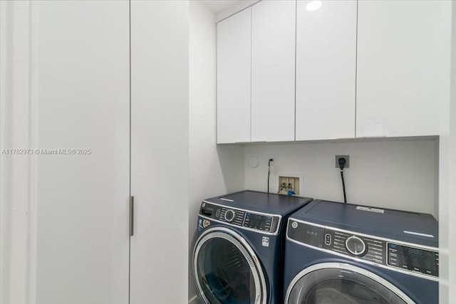 laundry room with independent washer and dryer and cabinet space
