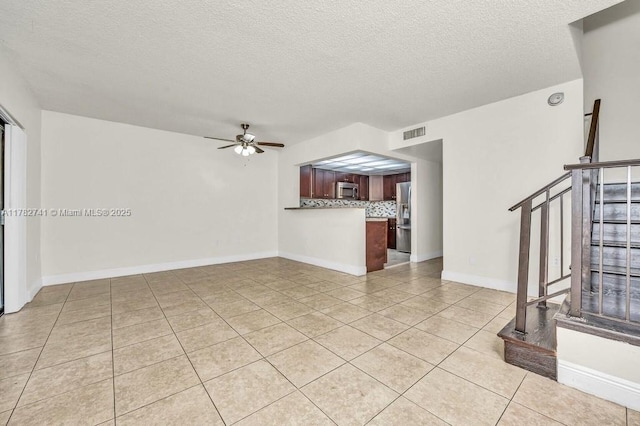 9050 NW 28th St Unit 114, Coral Springs, FL 33065 - unfurnished living room with light tile patterned floors, stairs, a textured ceiling, and a ceiling fan