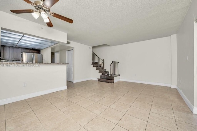 9050 NW 28th St Unit 114, Coral Springs, FL 33065 - unfurnished living room with a ceiling fan, a textured ceiling, light tile patterned floors, and stairs