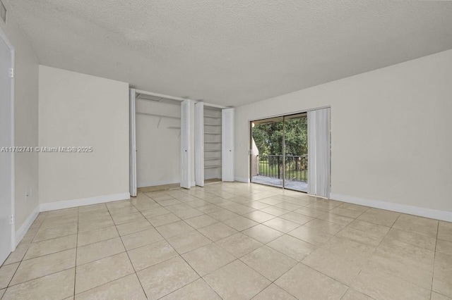 9050 NW 28th St Unit 114, Coral Springs, FL 33065 - spare room featuring a textured ceiling and light tile patterned flooring