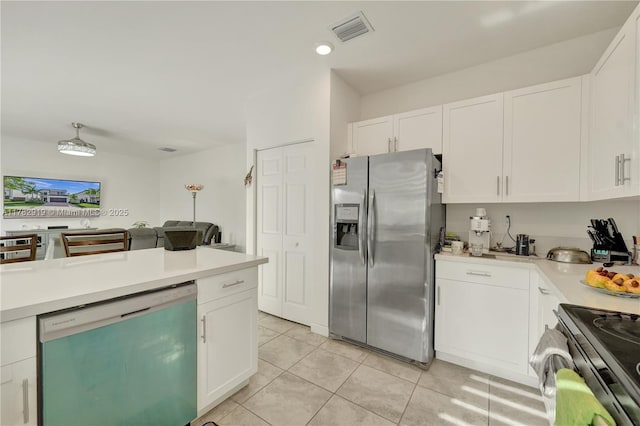 20900 NE 2nd Ct, Miami, FL 33179 - kitchen featuring light tile patterned floors, white cabinetry, light countertops, and appliances with stainless steel finishes