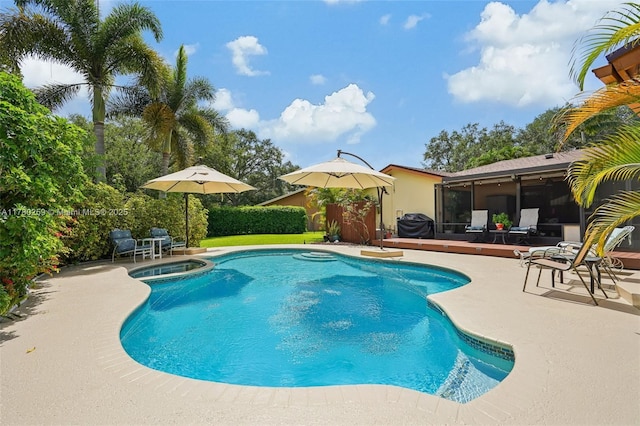 view of swimming pool featuring a patio area, a pool with connected hot tub, and a sunroom