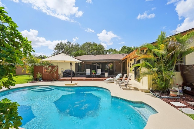 outdoor pool featuring fence, a patio, a sunroom, and area for grilling