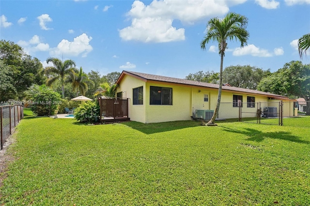 back of property featuring a fenced backyard, stucco siding, a gate, and a lawn