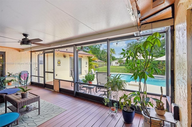 sunroom / solarium with a ceiling fan