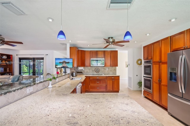 kitchen with stainless steel appliances, visible vents, brown cabinetry, and ceiling fan