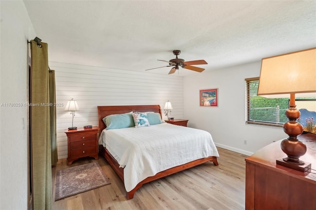 bedroom with light wood-style floors, baseboards, and ceiling fan