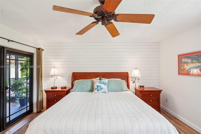 bedroom with access to exterior, ceiling fan, wood finished floors, and baseboards
