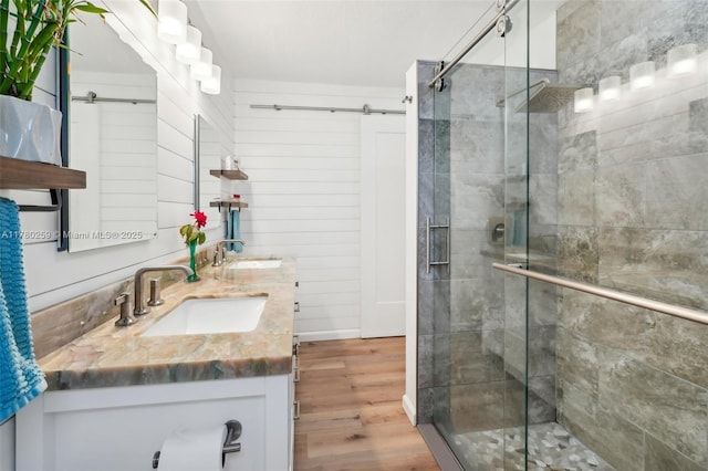 full bathroom with a shower stall, a sink, and wood finished floors
