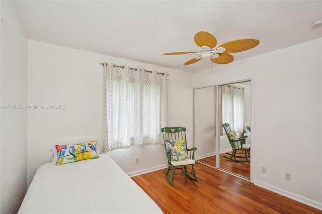 bedroom featuring wood finished floors, baseboards, and multiple windows