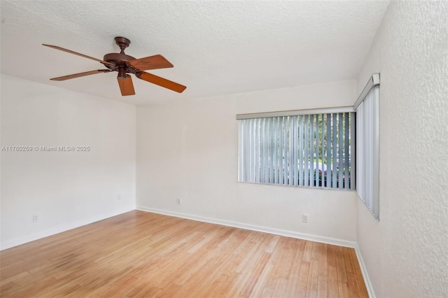 spare room with ceiling fan, baseboards, a textured ceiling, and wood finished floors