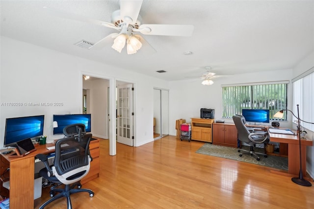 home office featuring french doors, light wood-type flooring, visible vents, and ceiling fan