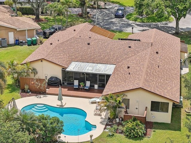 view of pool featuring a sunroom, a yard, a patio, a fenced in pool, and a deck