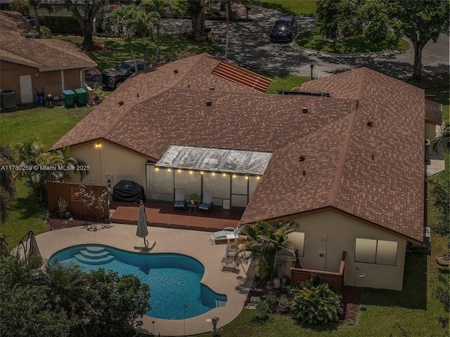view of pool with central AC unit, a wooden deck, a fenced in pool, and a patio