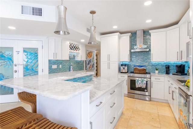 100 S Birch Rd Unit 1602C, Fort Lauderdale, FL 33316 - kitchen featuring stainless steel range with electric cooktop, wall chimney exhaust hood, decorative backsplash, a breakfast bar, and a peninsula