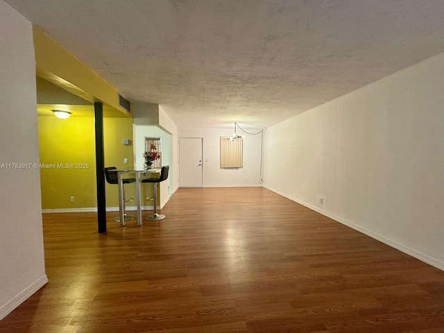empty room with wood finished floors, baseboards, and visible vents