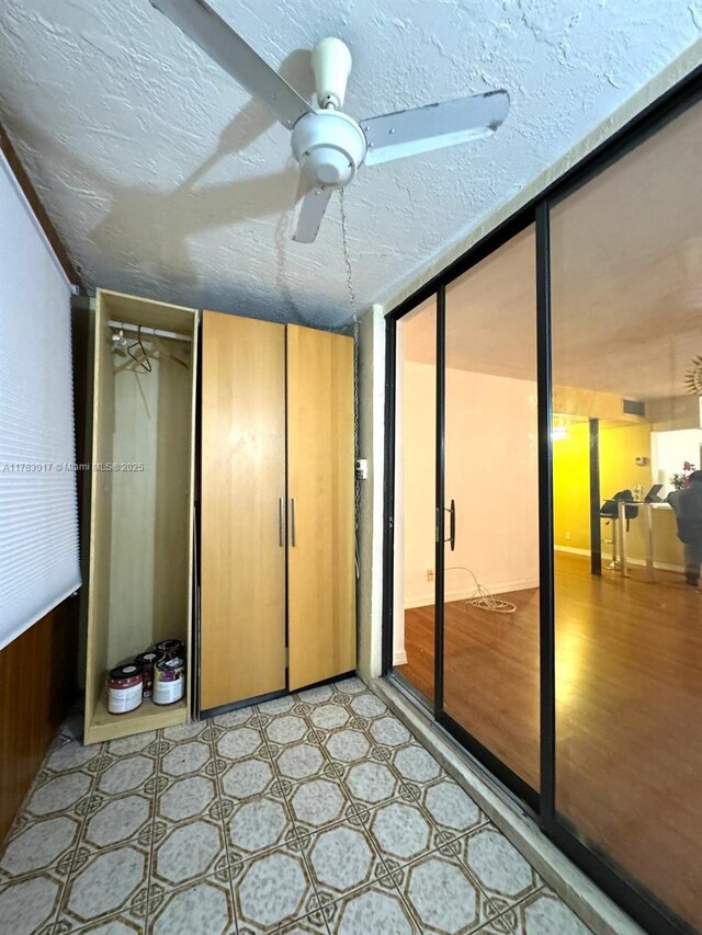 interior space featuring a textured ceiling, two closets, a ceiling fan, and light floors