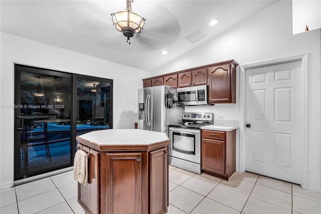 9 Bass Ave, Key Largo, FL 33037 - kitchen with stainless steel appliances, vaulted ceiling, light countertops, light tile patterned floors, and a center island