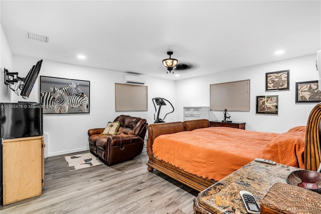 9 Bass Ave, Key Largo, FL 33037 - bedroom with light wood-type flooring, a wall mounted air conditioner, recessed lighting, and baseboards
