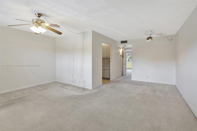unfurnished room with baseboards, light carpet, a textured ceiling, a ceiling fan, and visible vents