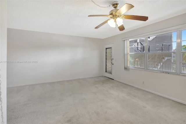 spare room featuring ceiling fan, baseboards, and carpet
