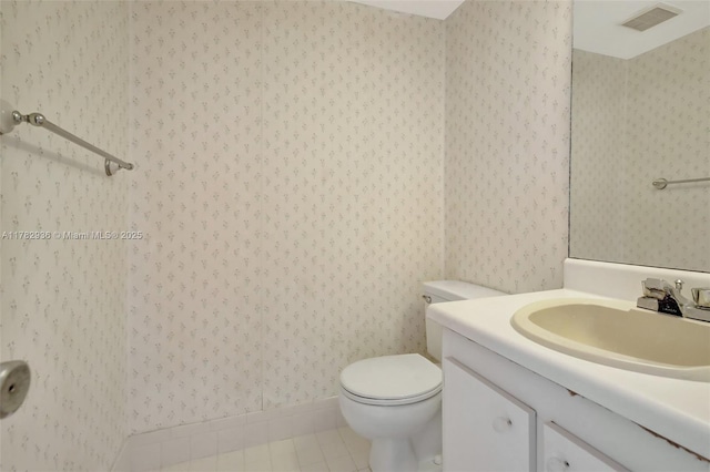 bathroom featuring vanity, wallpapered walls, tile patterned floors, toilet, and visible vents